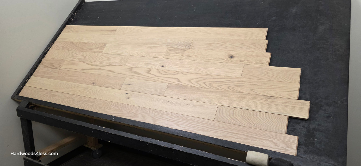 4" x 3/4" Solid Red Oak Doe Hardwood Flooring. Shown on a black shooting table. Shot from wide right.