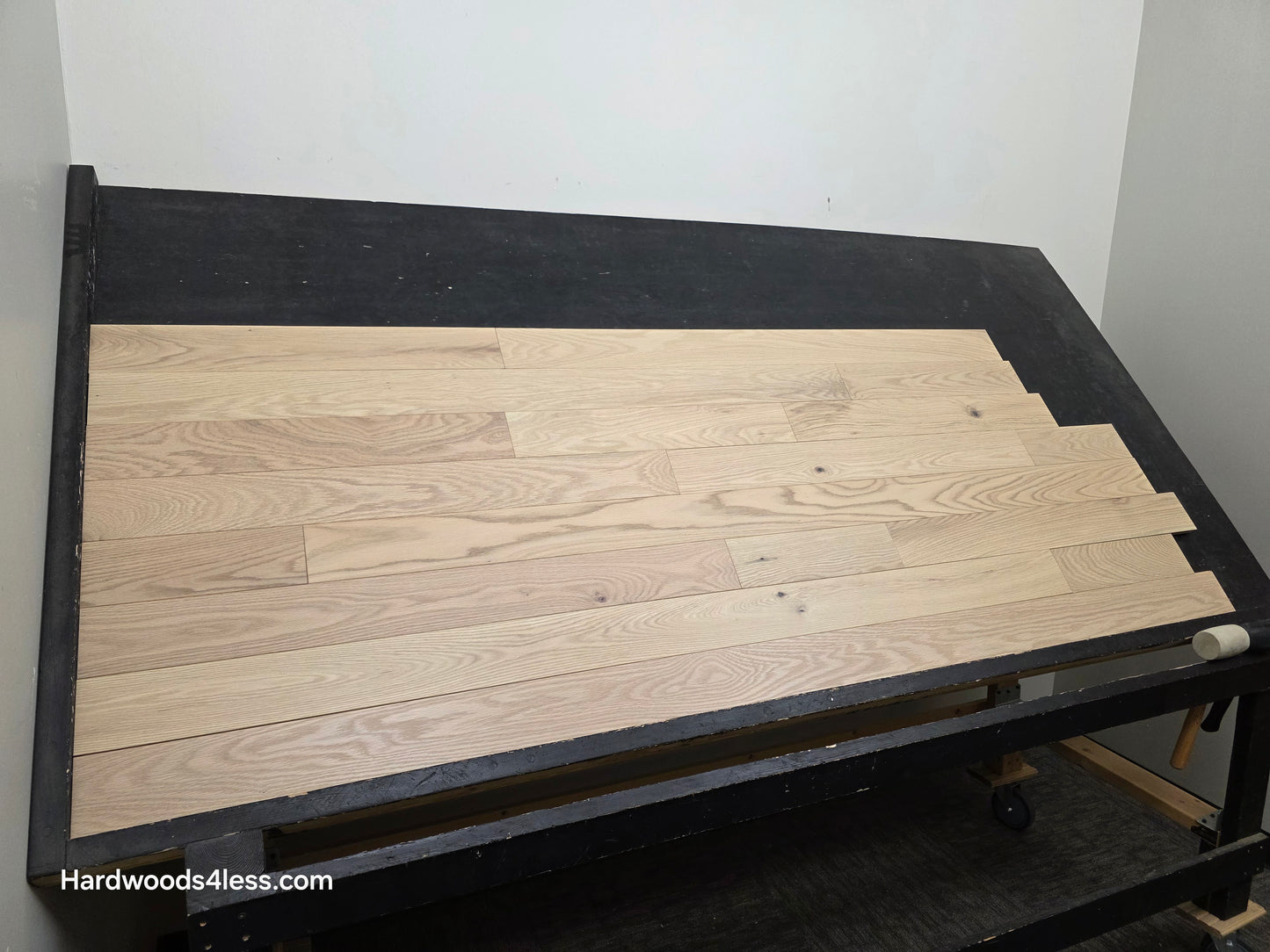 4" x 3/4" Solid Red Oak Doe Hardwood Flooring. Shown on a black shooting table. Shot from wide left.
