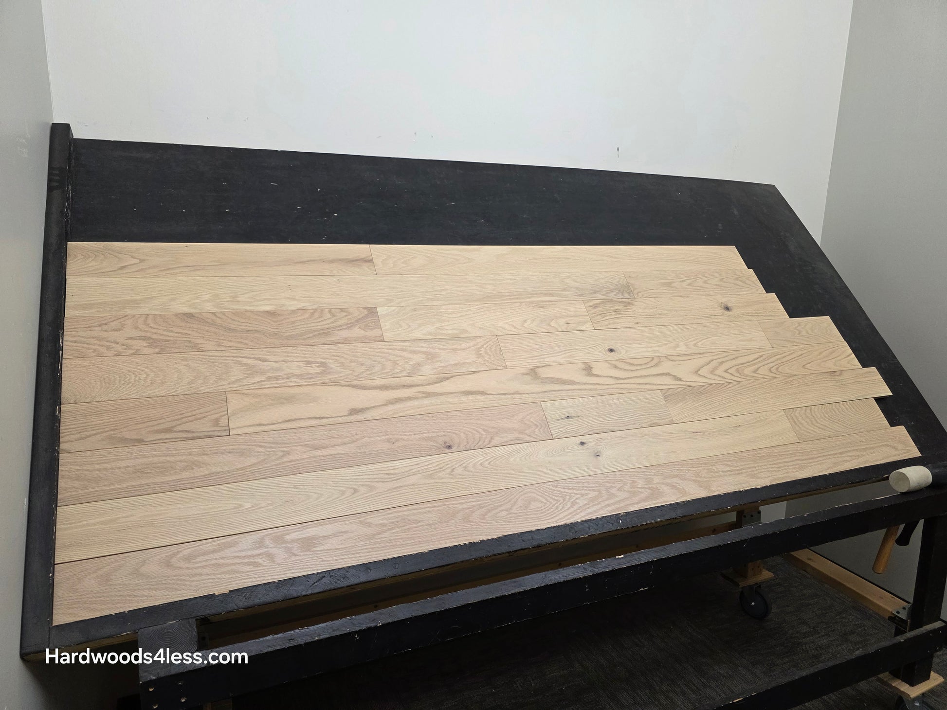 4" x 3/4" Solid Red Oak Doe Hardwood Flooring. Shown on a black shooting table. Shot from wide left.