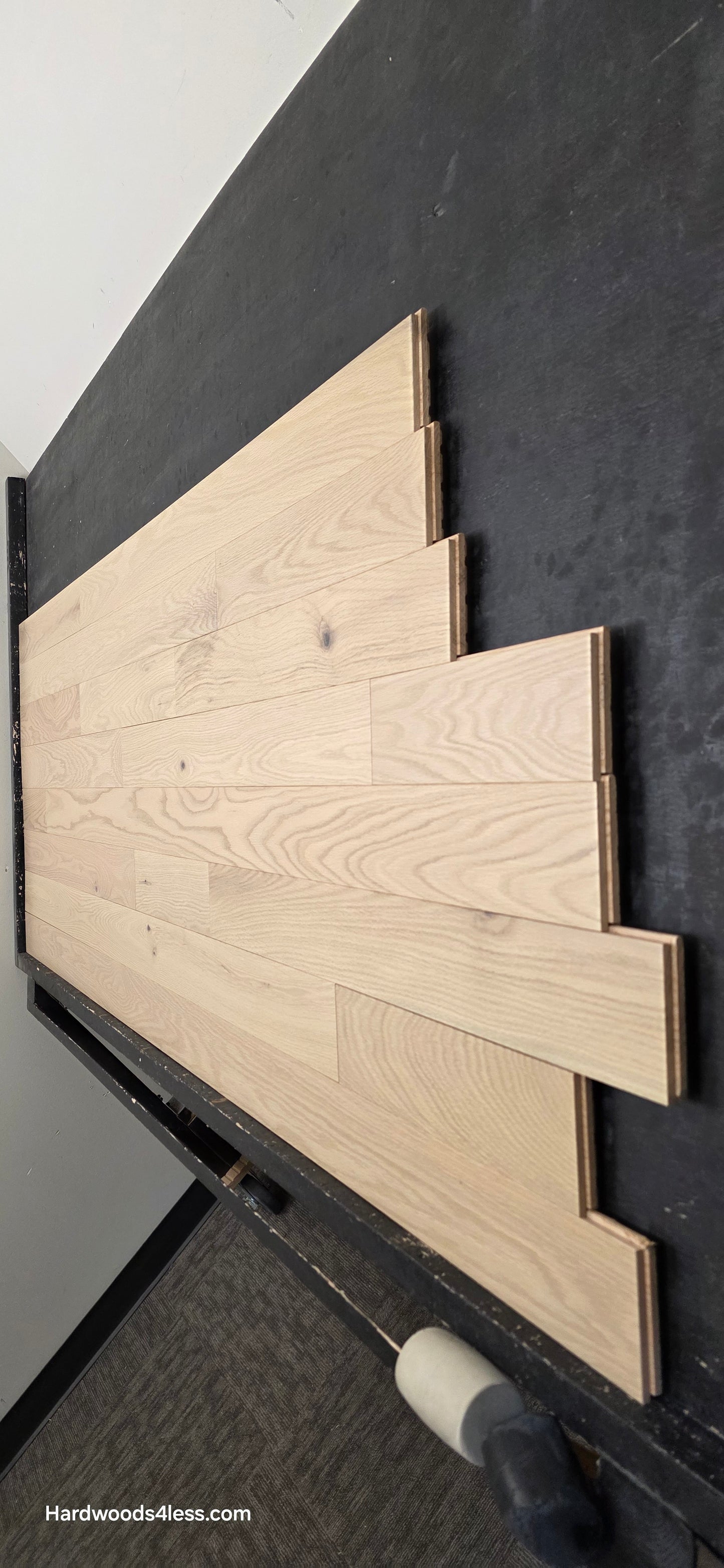 4" x 3/4" Solid Red Oak Doe Hardwood Flooring. Shown on a black shooting table. Shot from steep right.
