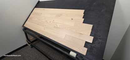 4" x 3/4" Solid Red Oak Doe Hardwood Flooring. Shown on a black shooting table. Shot from wide right.