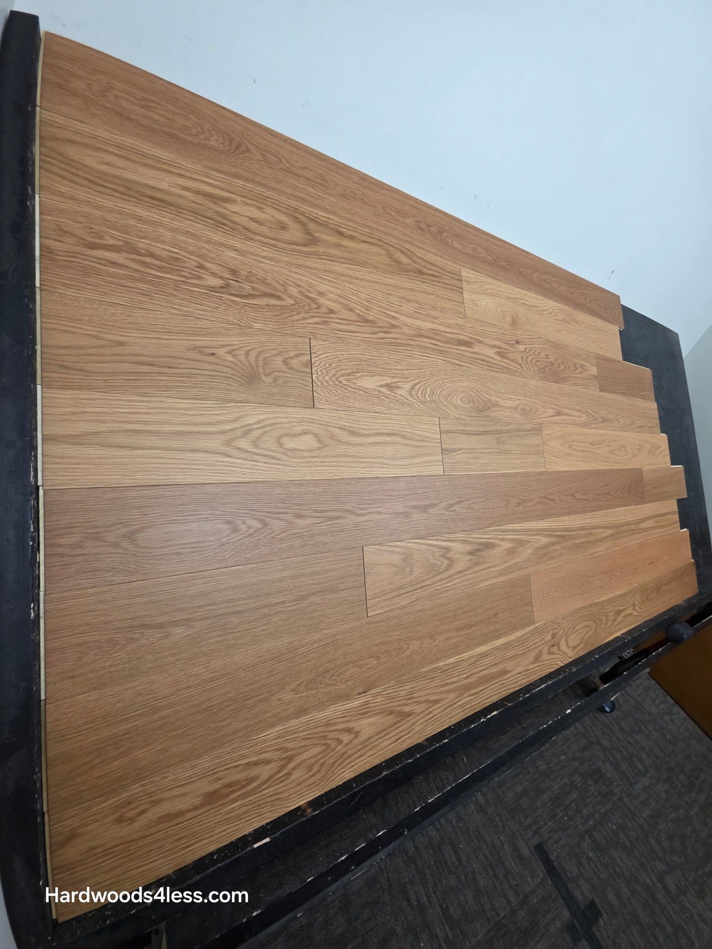 5 1/8" x 1/2"  Engineered White Oak Select & Better Natural Hardwood Flooring. Shown on a black shooting table. Shot from the left side. 