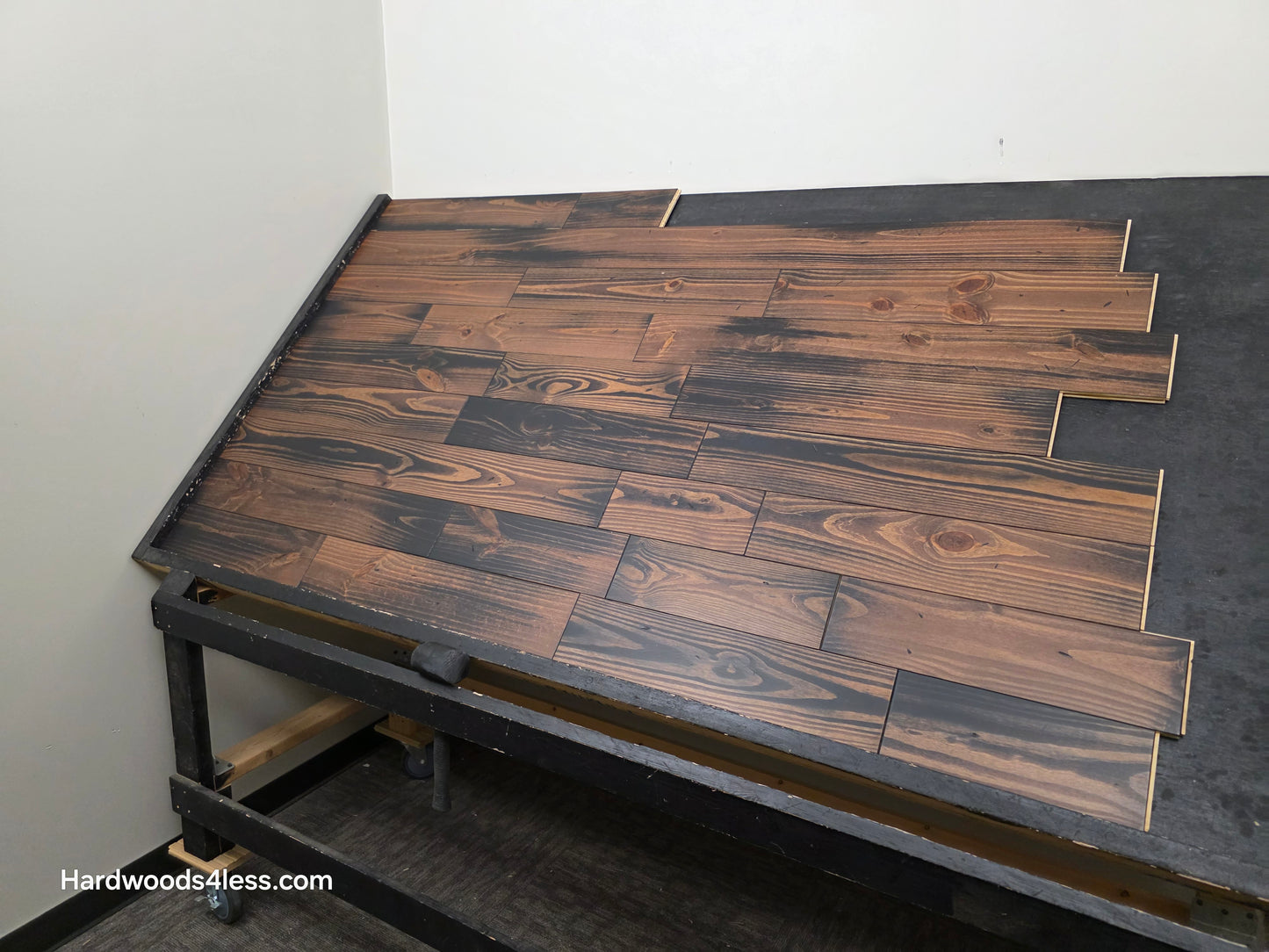 5 1/8" x 3/4" Southern Yellow Pine Charred Solid Hardwood Flooring. Shown on a black shooting table. Shot from the right hand side.