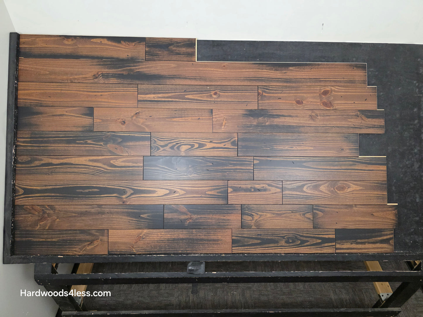 5 1/8" x 3/4" Southern Yellow Pine Charred Solid Hardwood Flooring. Shown on a black shooting table. Shot from center.