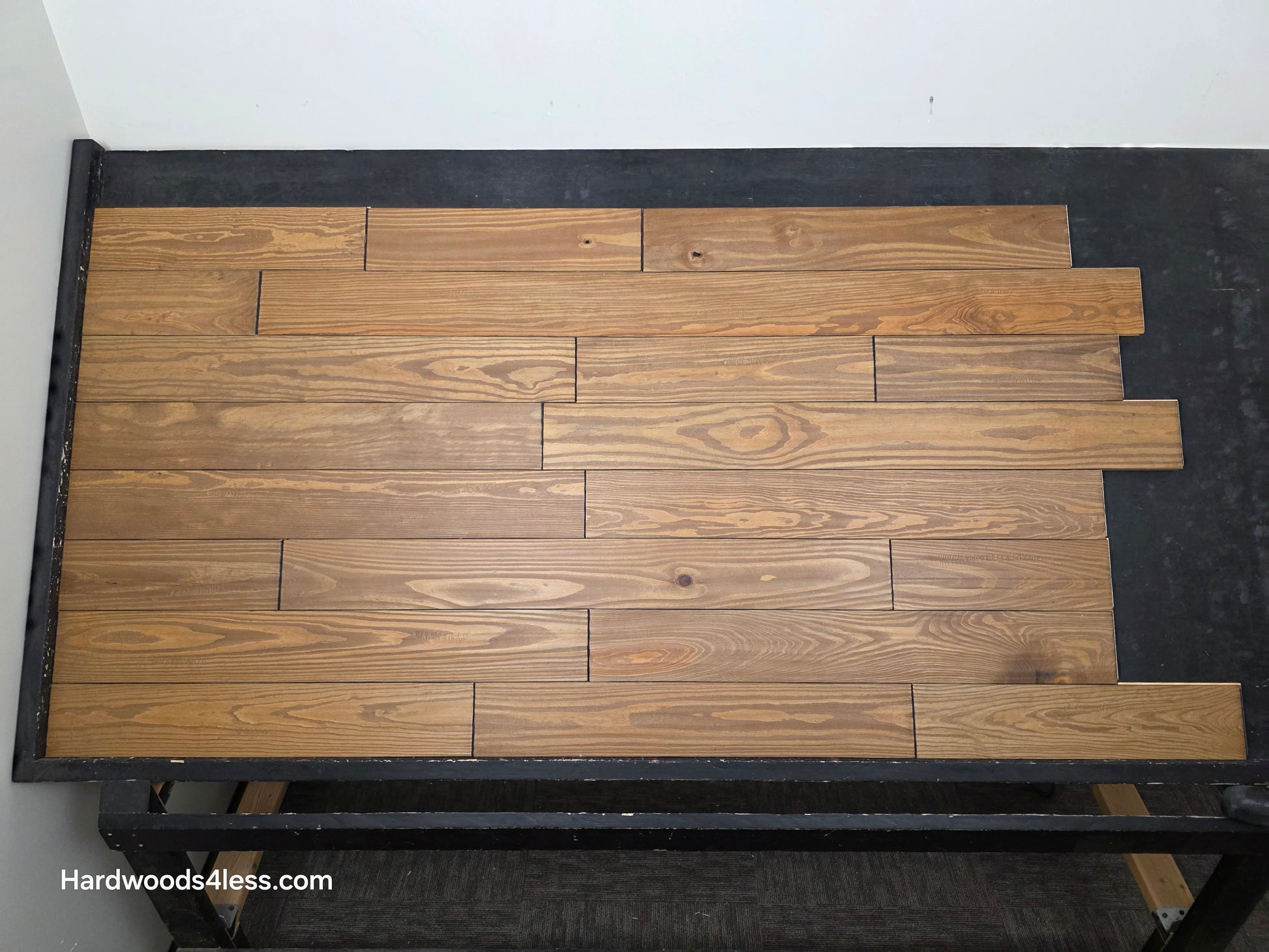 5 1/8" x 3/4" Southern Yellow Pine Ginger Solid Hardwood Flooring. Shown on a black shooting table. Head on shot.