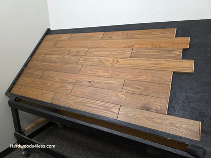 5 1/8" x 3/4" Southern Yellow Pine Ginger Solid Hardwood Flooring. Shown on a black shooting table. Wide right hand shot.