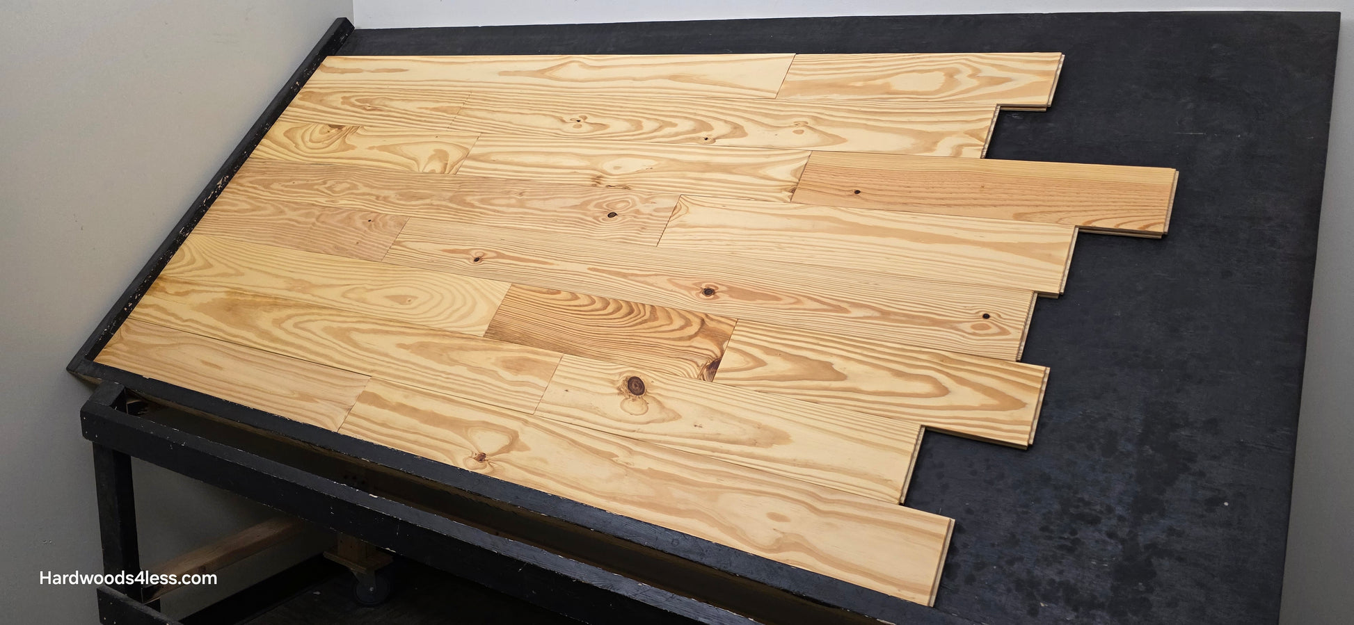 5 1/8" x 3/4" Southern Yellow Pine Wire Brushed Natural Solid Hardwood Flooring. Shown on a black shooting table. Shot from the right hand side. 