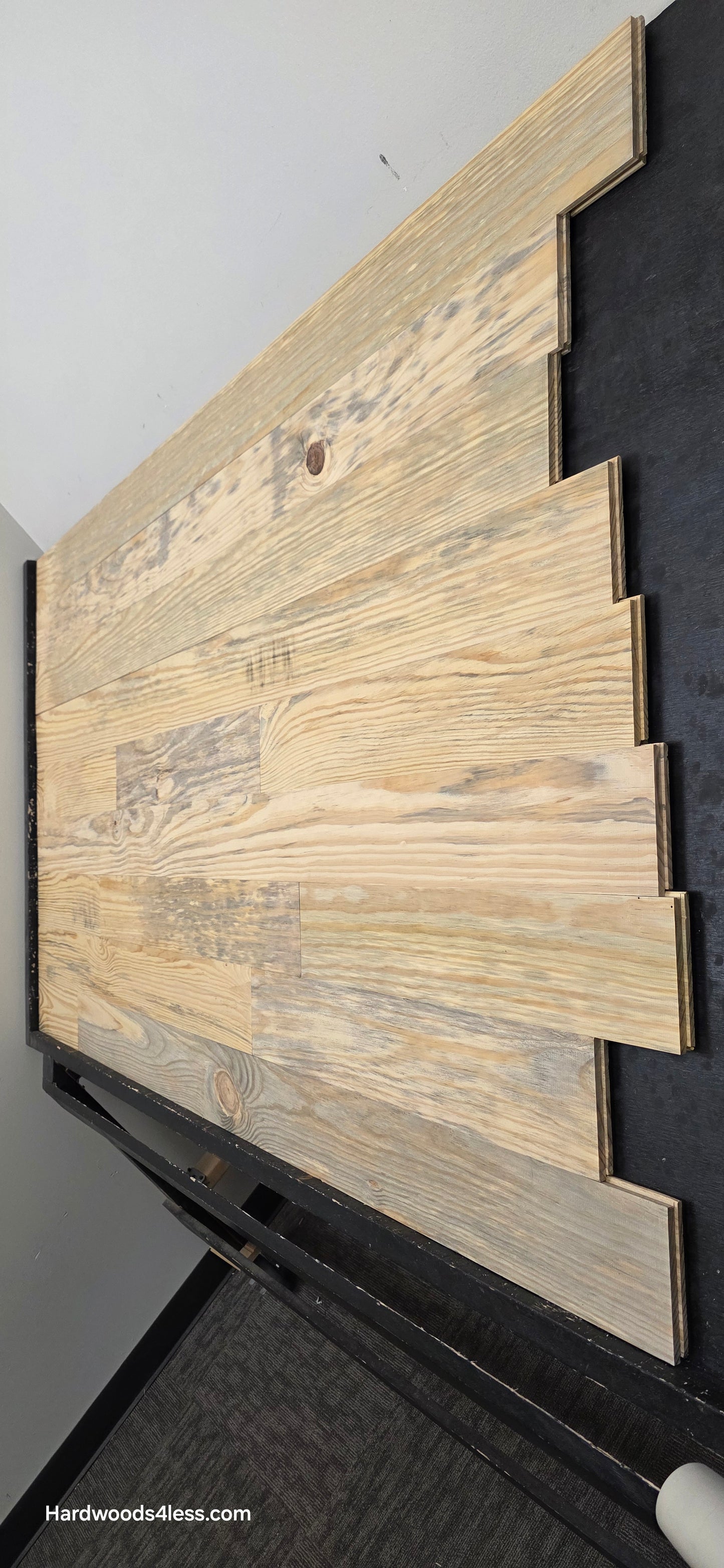 5 1/8" x 3/4" Unfinished Southern Yellow Pine Solid Flooring. Shown on a black shooting rack. Shot steep from the right hand side. 