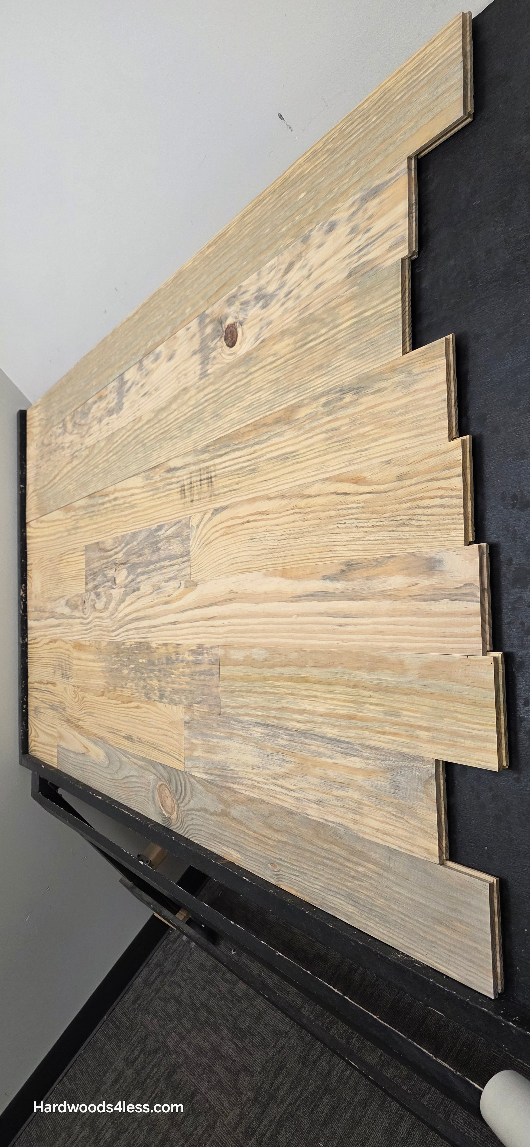 5 1/8" x 3/4" Unfinished Southern Yellow Pine Solid Flooring. Shown on a black shooting rack. Shot steep from the right hand side. 