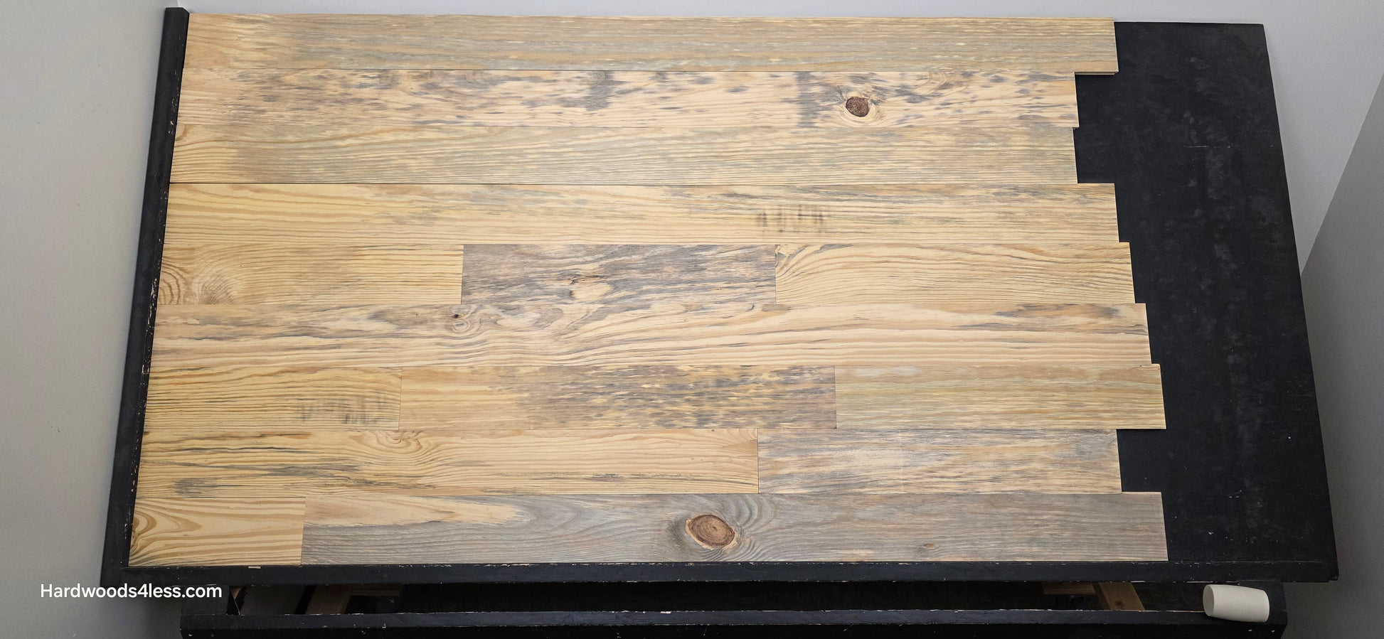 5 1/8" x 3/4" Unfinished Southern Yellow Pine Solid Flooring. Shown on a black shooting rack. Shot head on.