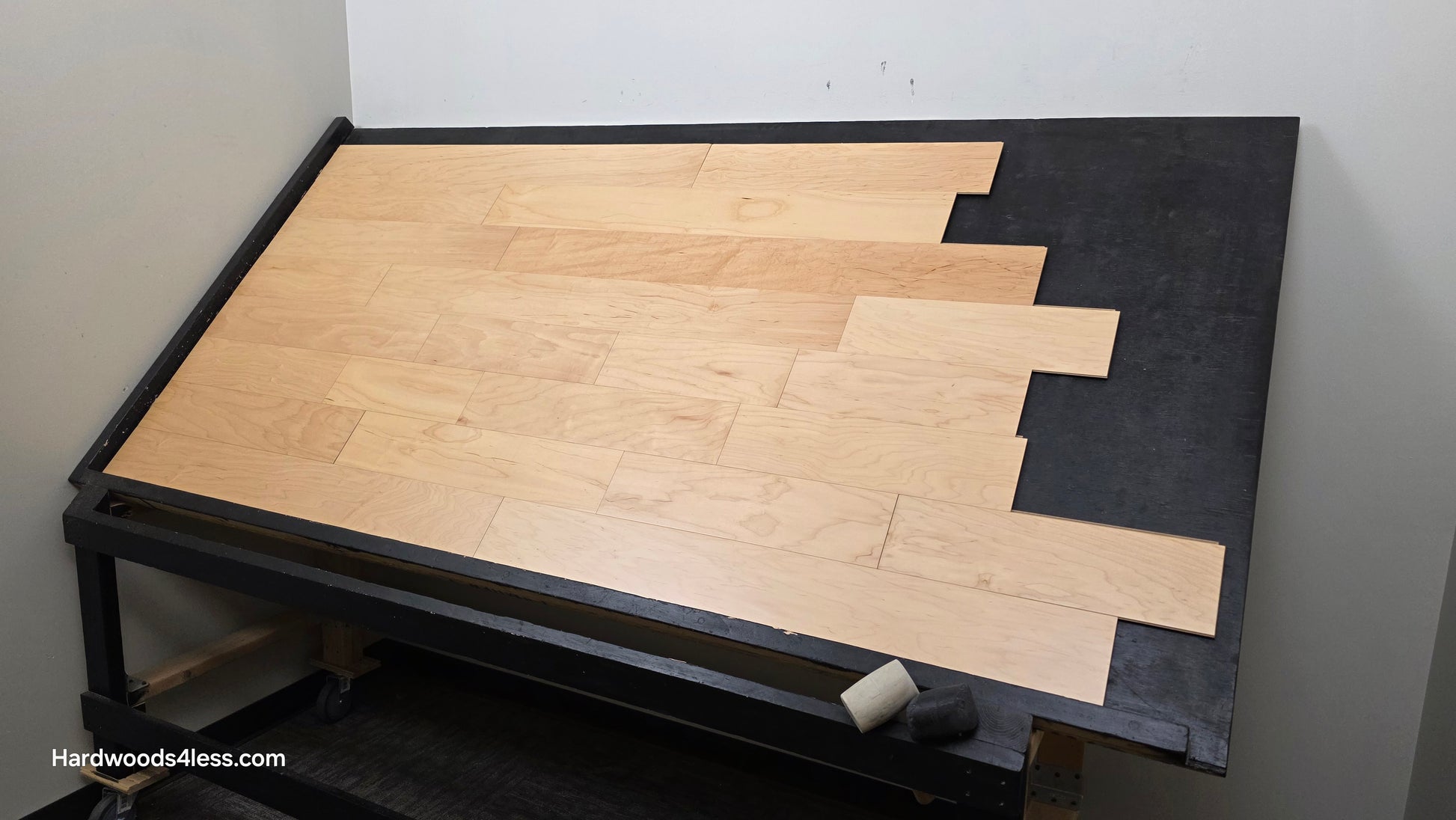 5 3/8" x 3/8" Engineered Maple Natural Hardwood Flooring. Shown on a black shooting table. Shot from wide right. 