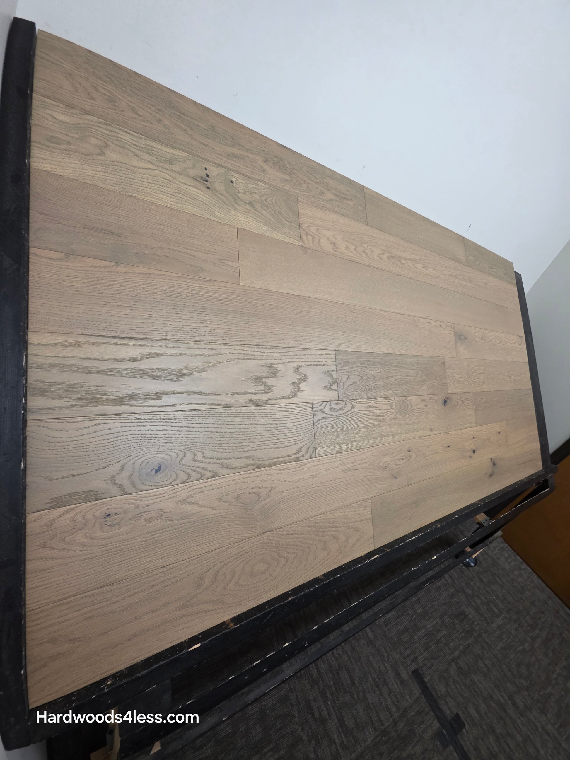 5 7/8" x 9/16" Engineered European Oak Cades Cove Hardwood Flooring. Shown on a black shooting table shown from the left side. 