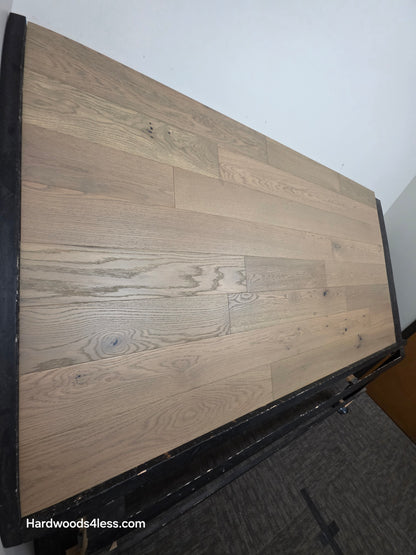 5 7/8" x 9/16" Engineered European Oak Cades Cove Hardwood Flooring. Shown on a black shooting table shown from the left side. 