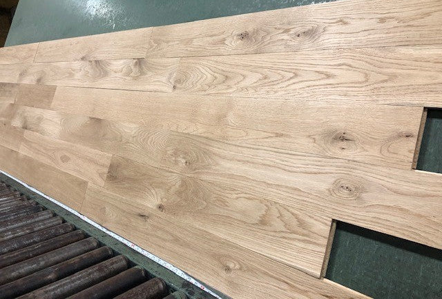 5" x 3/4" Unfinished White Oak #1 Common Solid Hardwood Flooring shown on a green shooting table with rollers at the base 