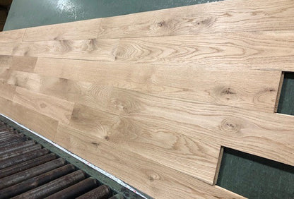 5" x 3/4" Unfinished White Oak #1 Common Solid Hardwood Flooring shown on a green shooting table with rollers at the base 