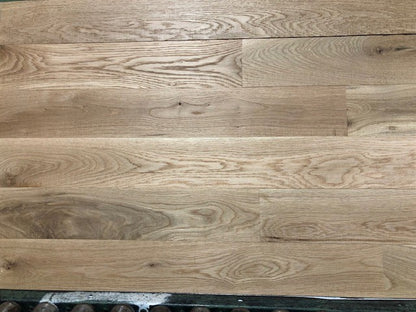 5" x 3/4" Unfinished White Oak #1 Common Solid Hardwood Flooring shown on a green shooting table with rollers at the base 