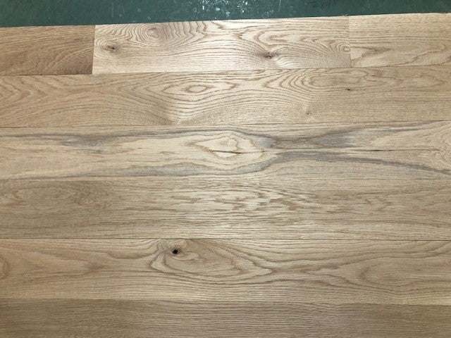 5" x 3/4" Unfinished White Oak #1 Common Solid Hardwood Flooring shown on a green shooting table with rollers at the base 