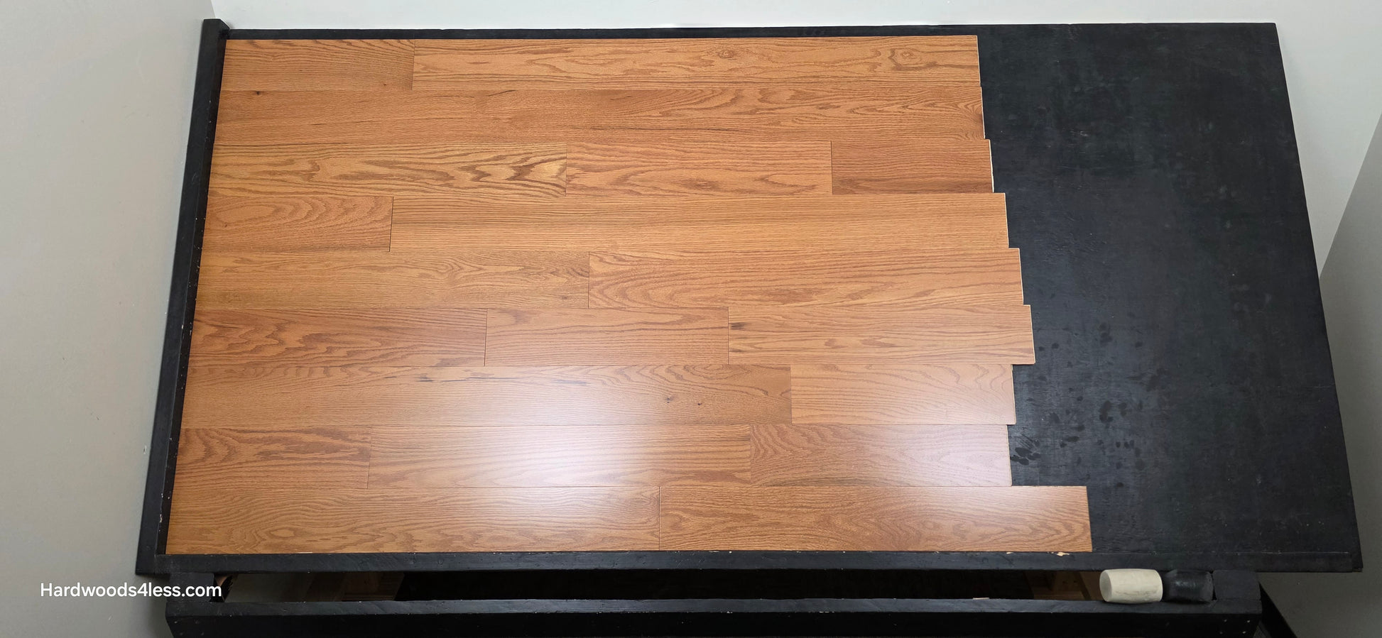 5" x 1/2" Engineered Red Oak Golden Oak Hardwood Flooring. Shown on a black shooting table. Shot from center.