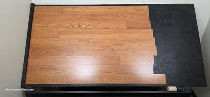 5" x 1/2" Engineered Red Oak Golden Oak Hardwood Flooring. Shown on a black shooting table. Shot from center.