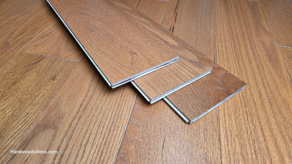 5" x 1/2" Engineered Red Oak Golden Oak Hardwood Flooring. Three wood flooring planks are shown at center. The planks are sitting on top of the Golden Oak flooring. 