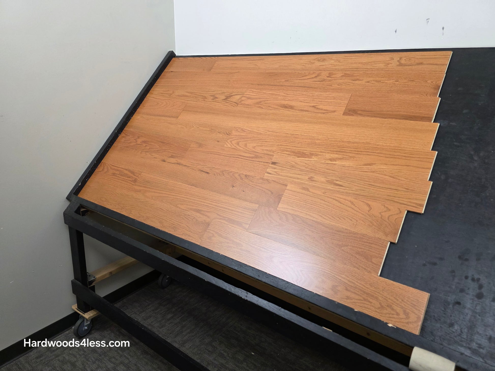 5" x 1/2" Engineered Red Oak Golden Oak Hardwood Flooring. Shown on a black shooting table. Shot from wide right.