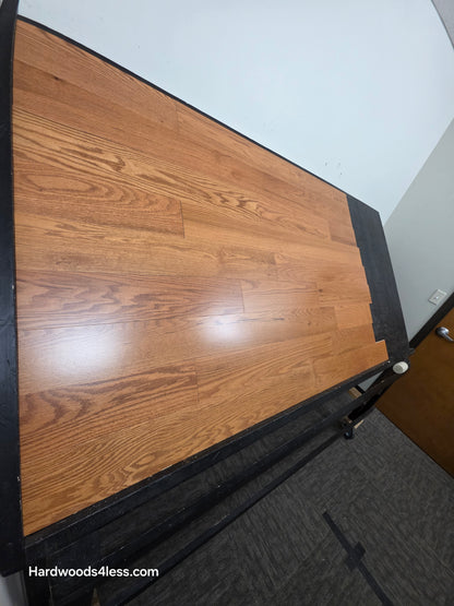 5" x 1/2" Engineered Red Oak Golden Oak Hardwood Flooring. Shown on a black shooting table. Shot from steep left. 