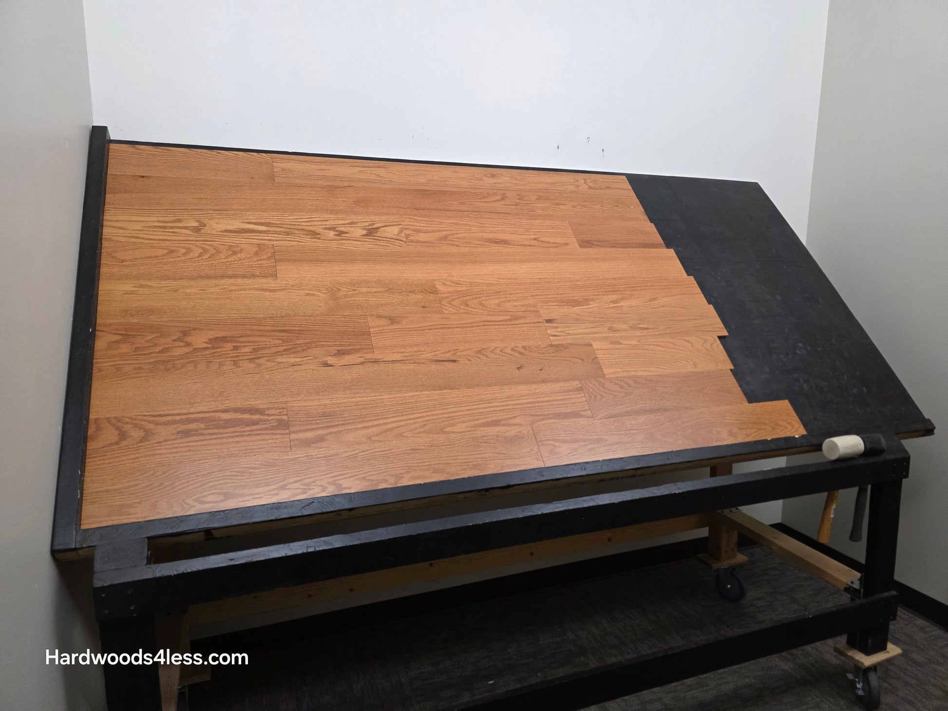 5" x 1/2" Engineered Red Oak Golden Oak Hardwood Flooring. Shown on a black shooting table. Shot from wide left.