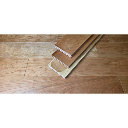 5" x 3/4" American Cherry Natural Hardwood Flooring shown as 3 planks stacked on top of each other at center. Under the planks is the Cherry flooring.