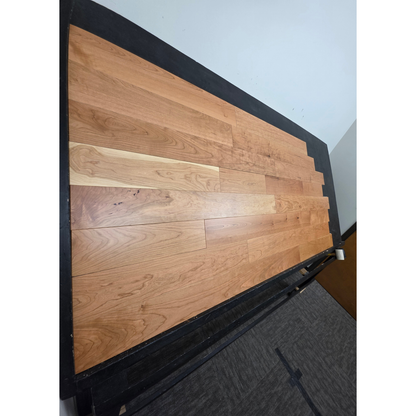 5" x 3/4" American Cherry Natural Hardwood Flooring shown on a black shooting table. Shot from steep left. 