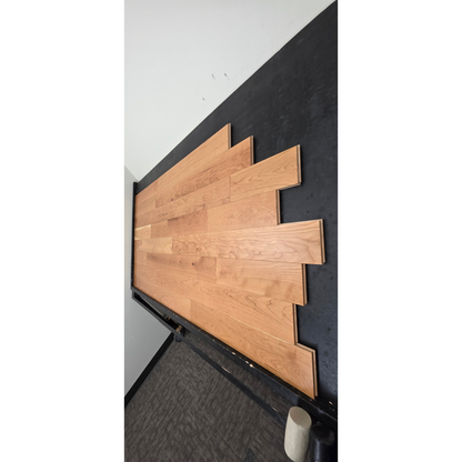 5" x 3/4" American Cherry Natural Hardwood Flooring shown on a black shooting table. Shot from steep right.