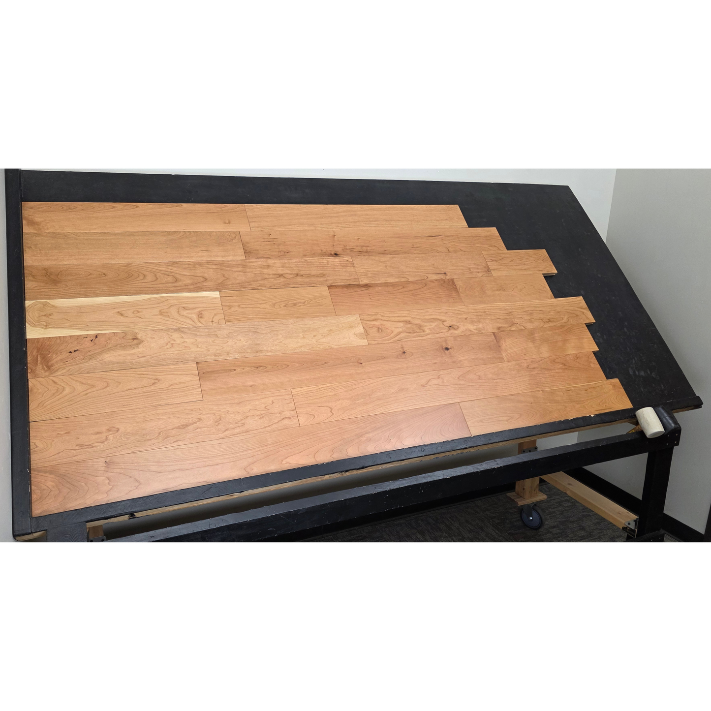 5" x 3/4" American Cherry Natural Hardwood Flooring shown on a black shooting table. Shot from wide left. 