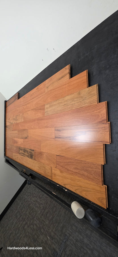 5" x 3/4" Prefinished Brazilian Cherry Shorts Hardwood Flooring. Shown on a black shooting table. Shot from steep right.