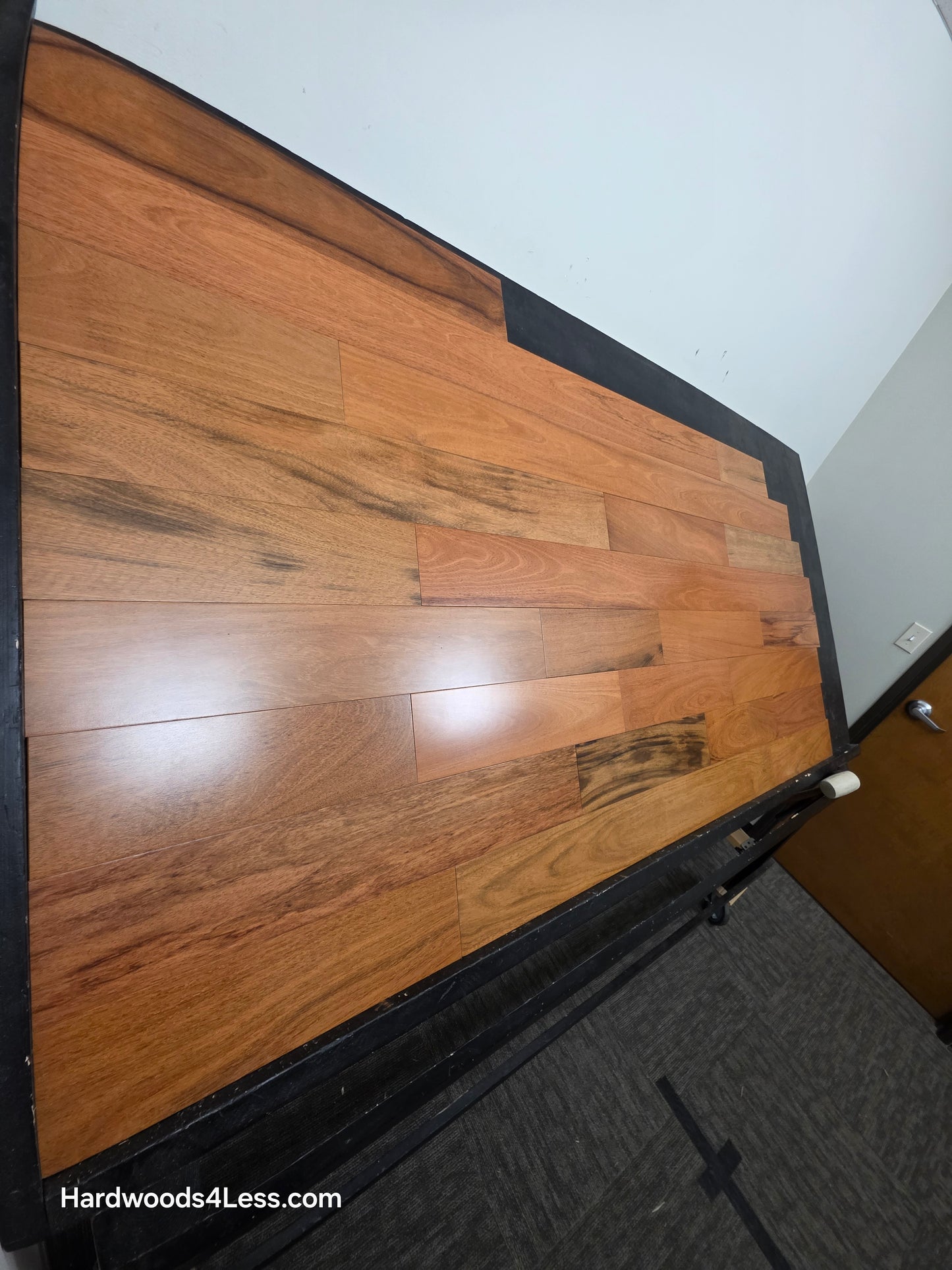 5" x 3/4" Prefinished Brazilian Cherry Shorts Hardwood Flooring. Shown on a black shooting table. Shot from steep left. 