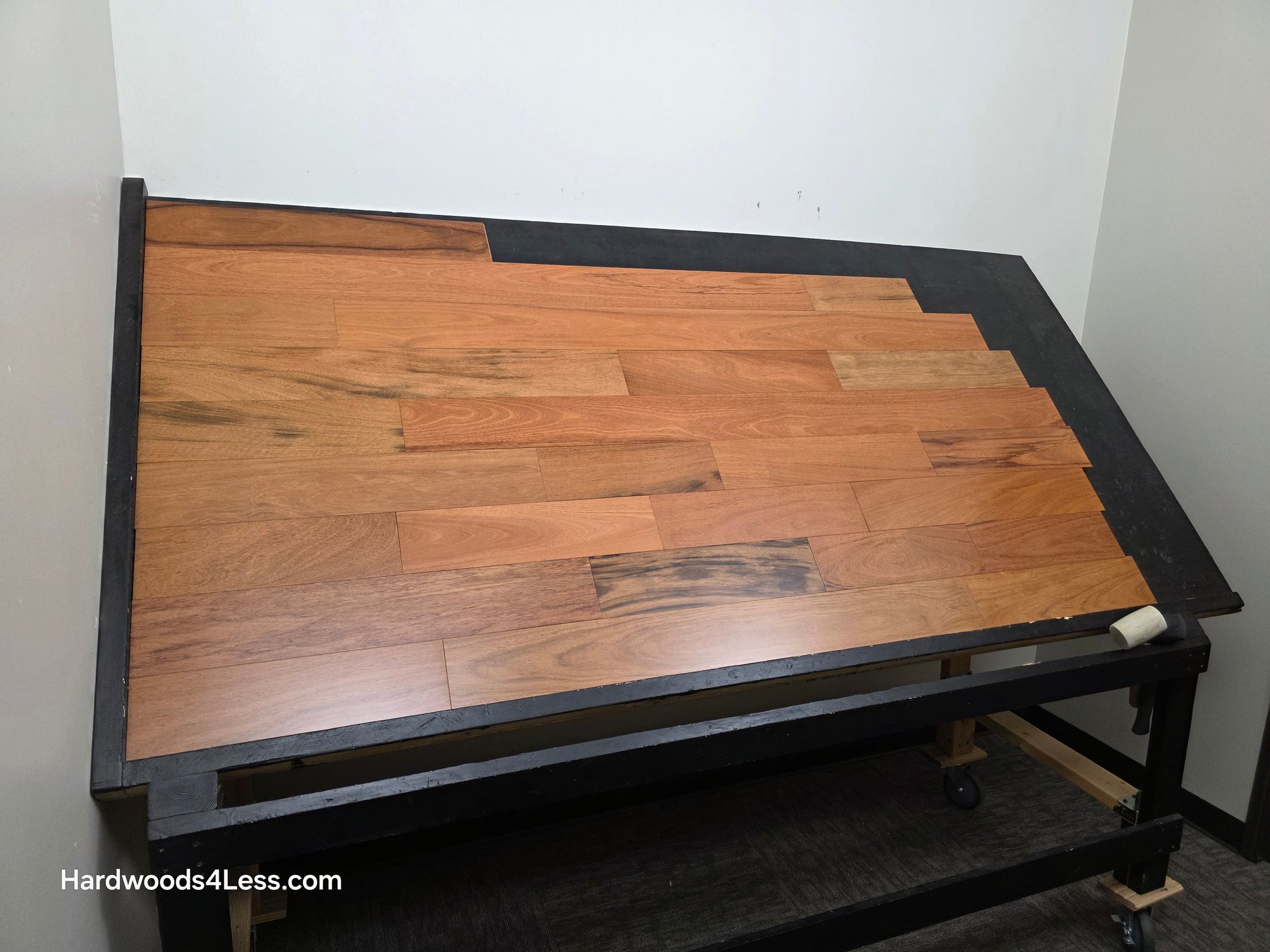 5" x 3/4" Prefinished Brazilian Cherry Shorts Hardwood Flooring. Shown on a black shooting table. Shot from wide left.