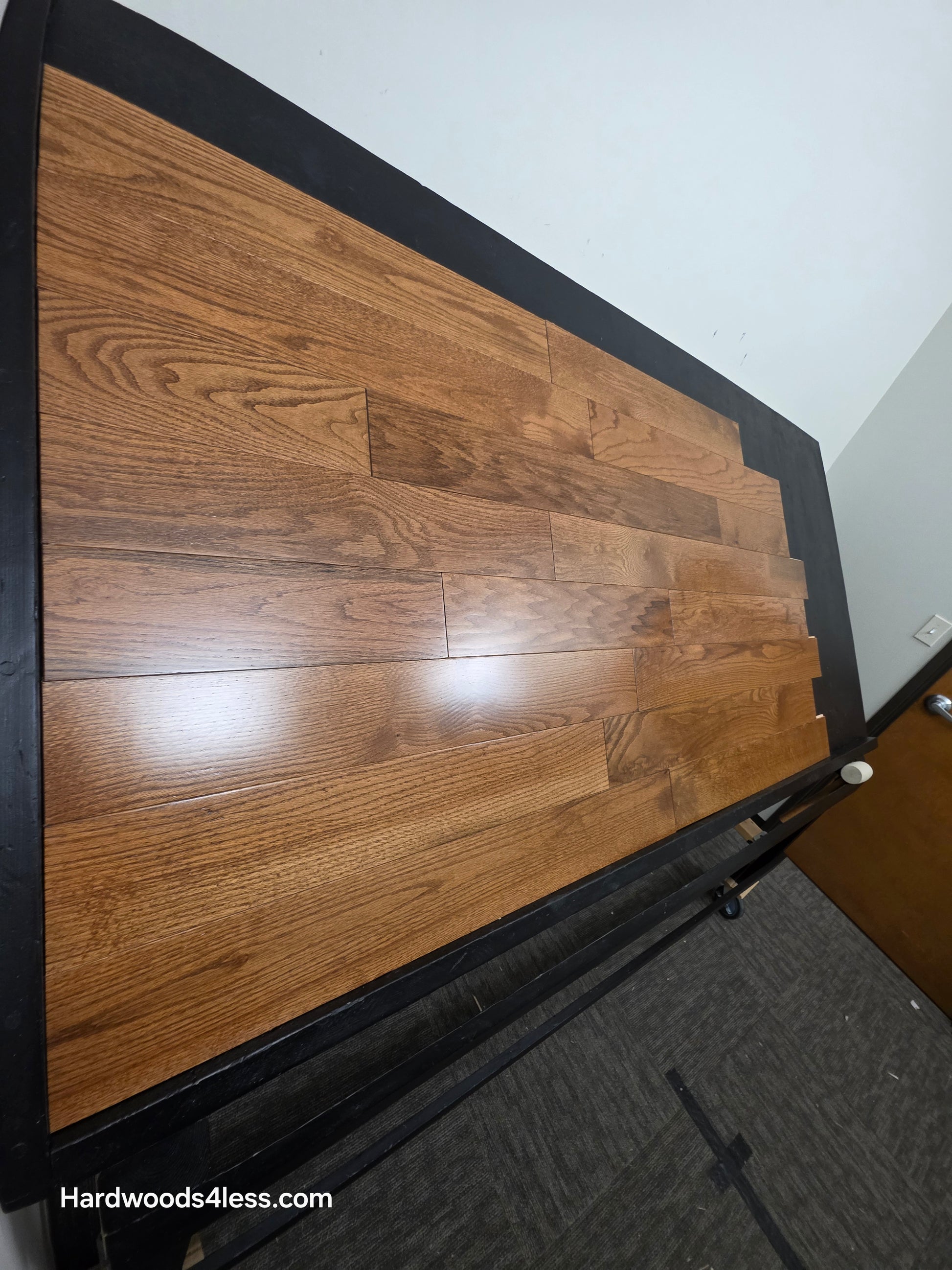 5 x 34 Solid Red Oak Hide Hardwood Flooring. Shown on a black shooting table. Shot from tight left. 