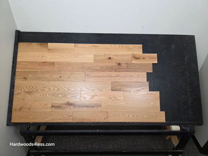 5" x 3/4" Solid Red Oak Low Gloss Common & Better Hardwood Flooring Shown on a black shooting table. Shot from center.