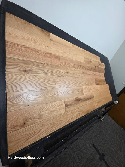 5" x 3/4" Solid Red Oak Low Gloss Common & Better Hardwood Flooring. Shown on a black shooting table. Shot steep left. 