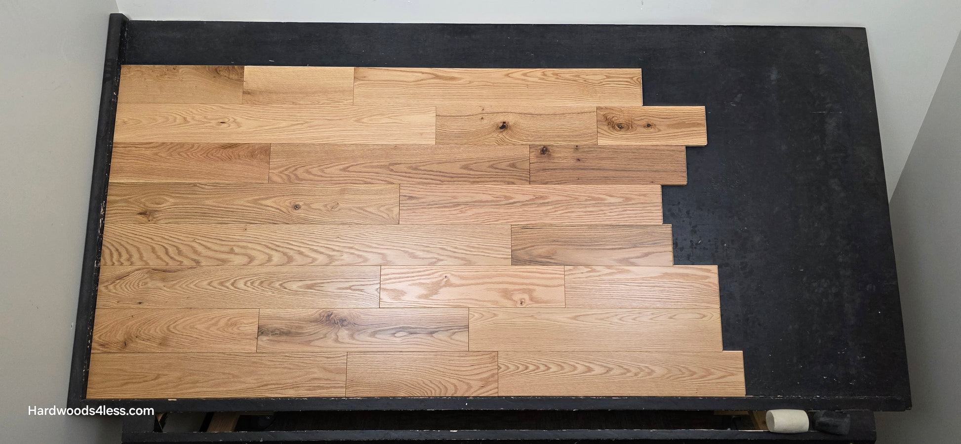 5" x 3/4" Solid Red Oak Low Gloss Common & Better Hardwood Flooring. Shown on a black shooting table. Shot close center. 