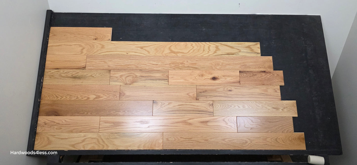 5" x 3/4" Solid Red Oak Natural Mill Run Hardwood Flooring. Shown on a black shooting table. Shot from the center.