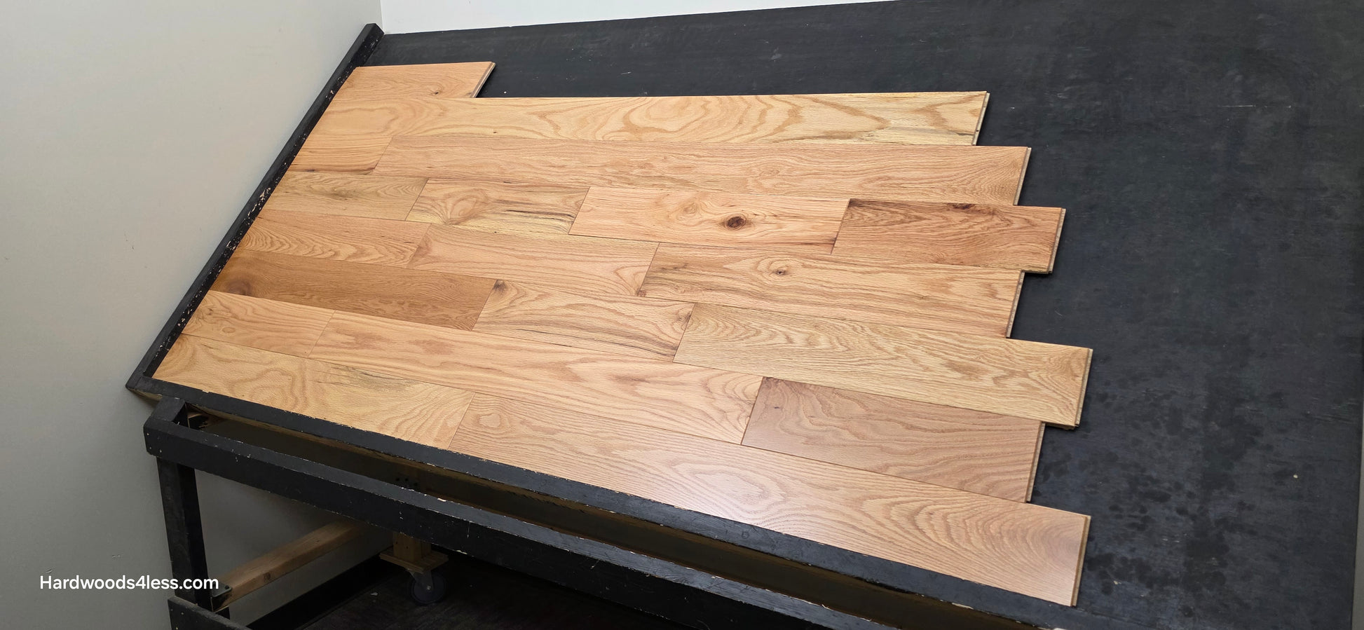 5" x 3/4" Solid Red Oak Natural Mill Run Hardwood Flooring. Shown on a black shooting table. Right hand shot. 