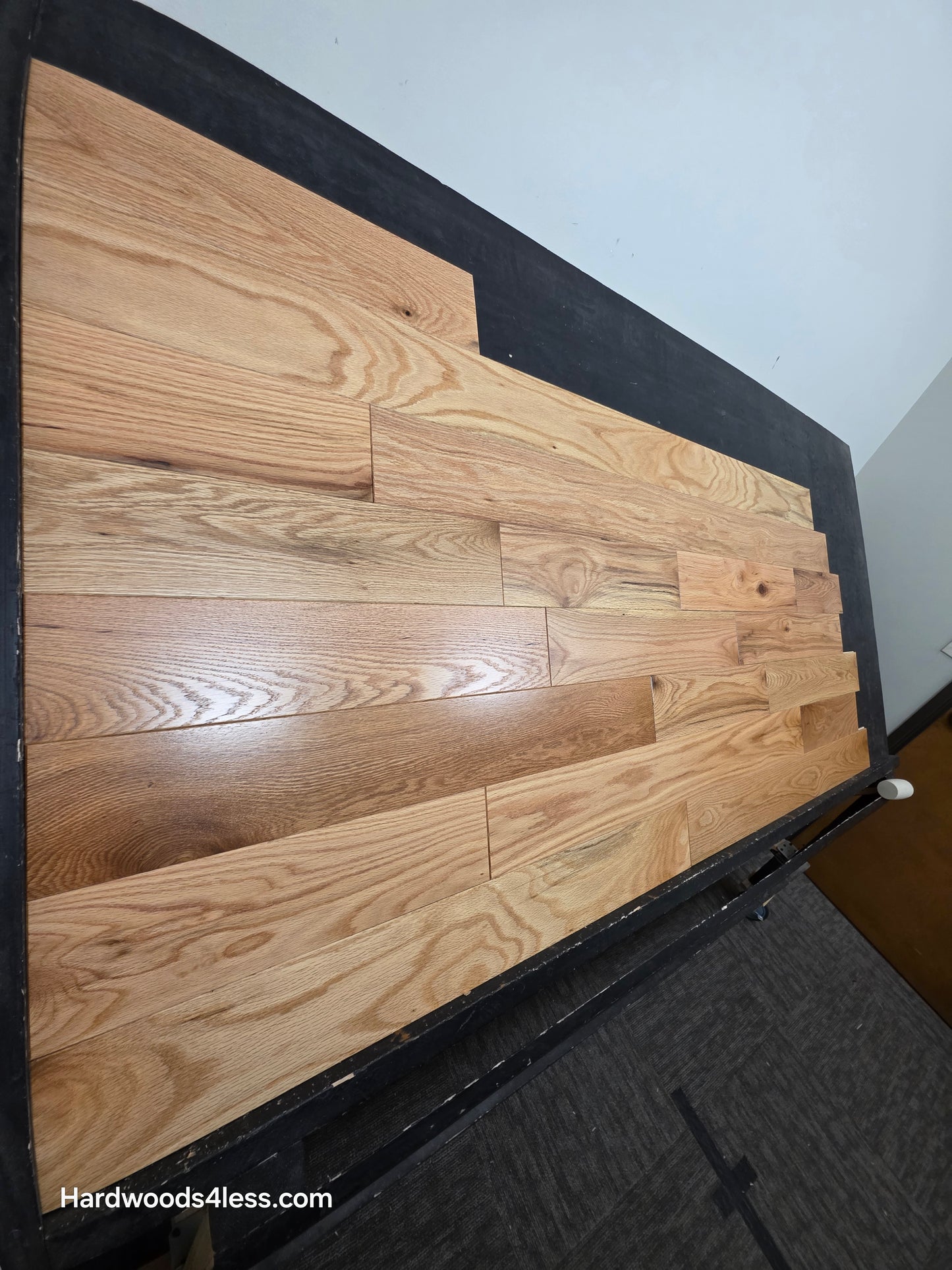 5" x 3/4" Solid Red Oak Natural Mill Run Hardwood Flooring. Shown on a black shooting table. Shot from far left. 