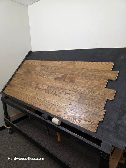 Solid Red Oak Purslane Hardwood Flooring shown on a black shooting rack from far away right
