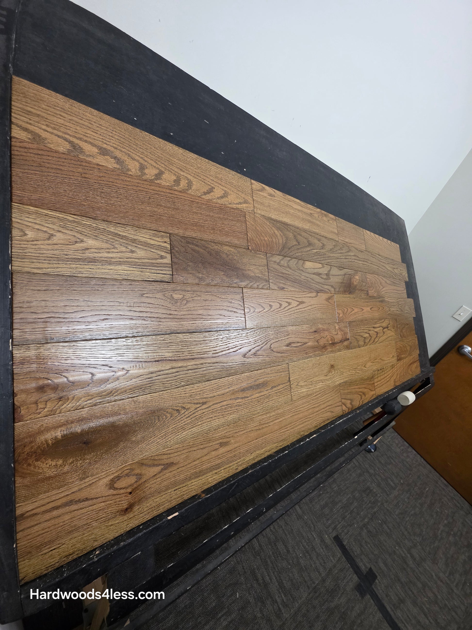 Solid Red Oak Purslane Hardwood Flooring shown on a black shooting rack shot from steep left