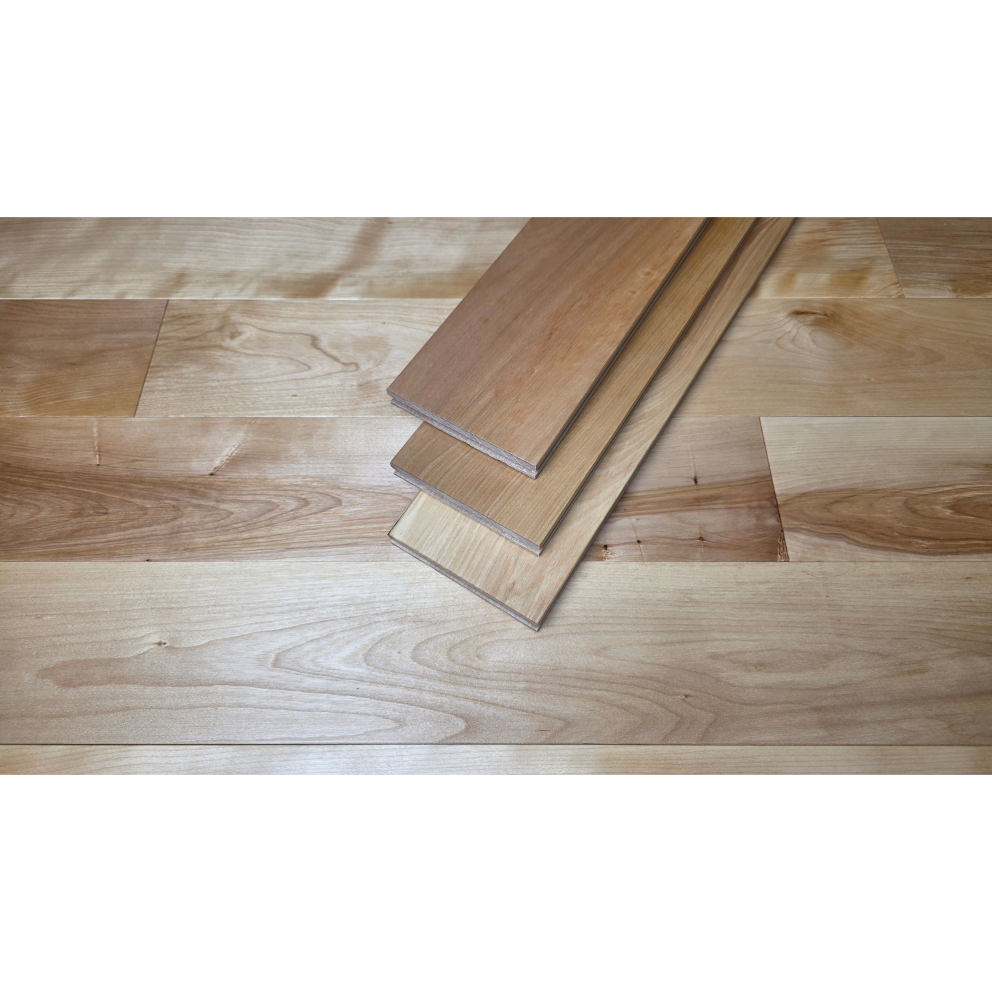 5" x 3/4" Solid Yellow Birch Natural Hardwood Flooring shown with 3 planks stacked at center. Under the planks is the Birch flooring. 