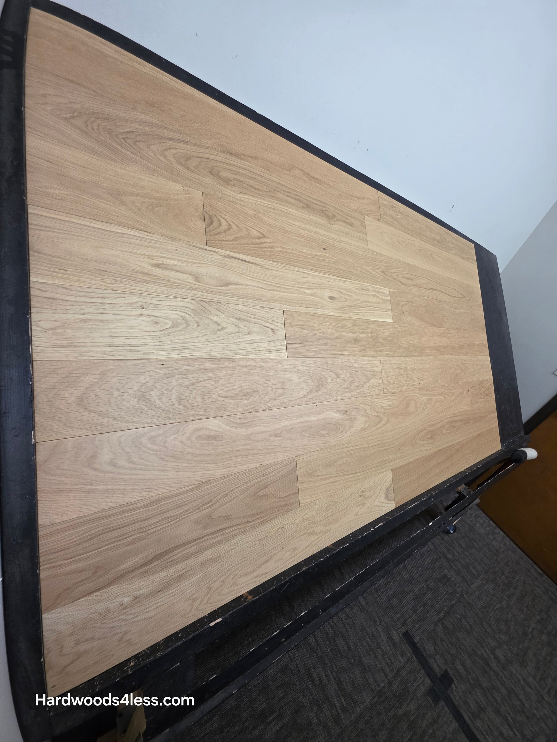 5" x 9/16" Engineered European Oak Natural Hardwood Flooring. Shown on a black shooting table shot from the steep left side.