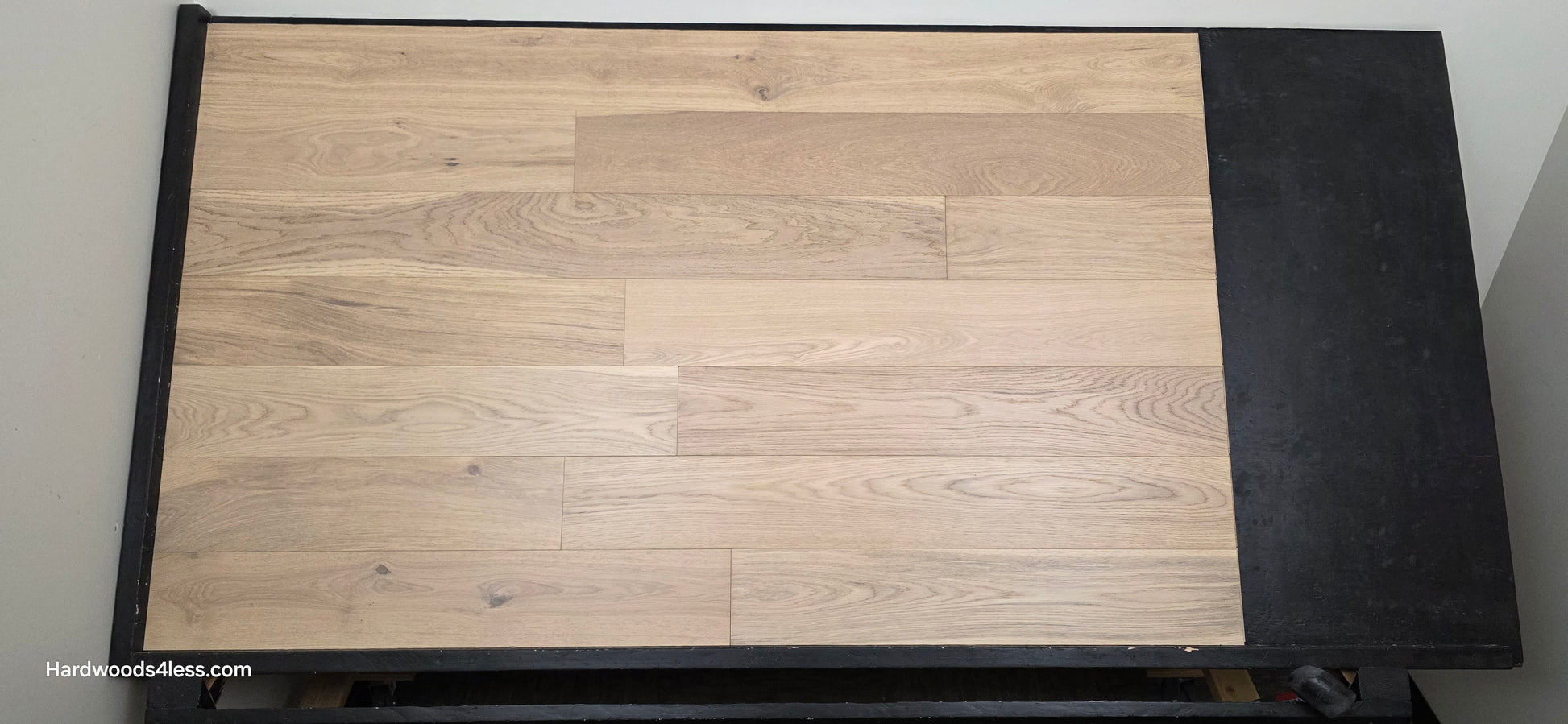 6 1/2" x 1/2" Engineered European White Oak Mojito Hardwood Flooring. Shown on a black shooting table. Shot from center.