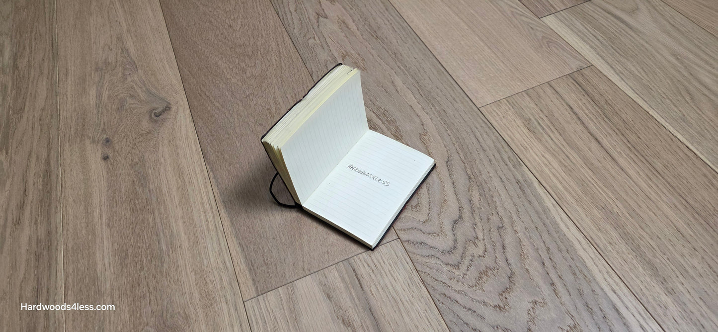 6 1/2" x 1/2" Engineered European White Oak Mojito Hardwood Flooring. Shown with an open small book with the words, Hardwoods4less, written in the center. 