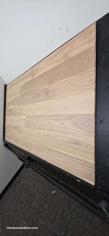 6 1/2" x 1/2" Engineered European White Oak Mojito Hardwood Flooring. Shown on a black shooting table. Shot from steep right.