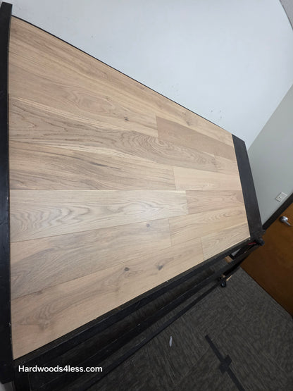 6 1/2" x 1/2" Engineered European White Oak Mojito Hardwood Flooring. Shown on a black shooting table. Shot from steep left.