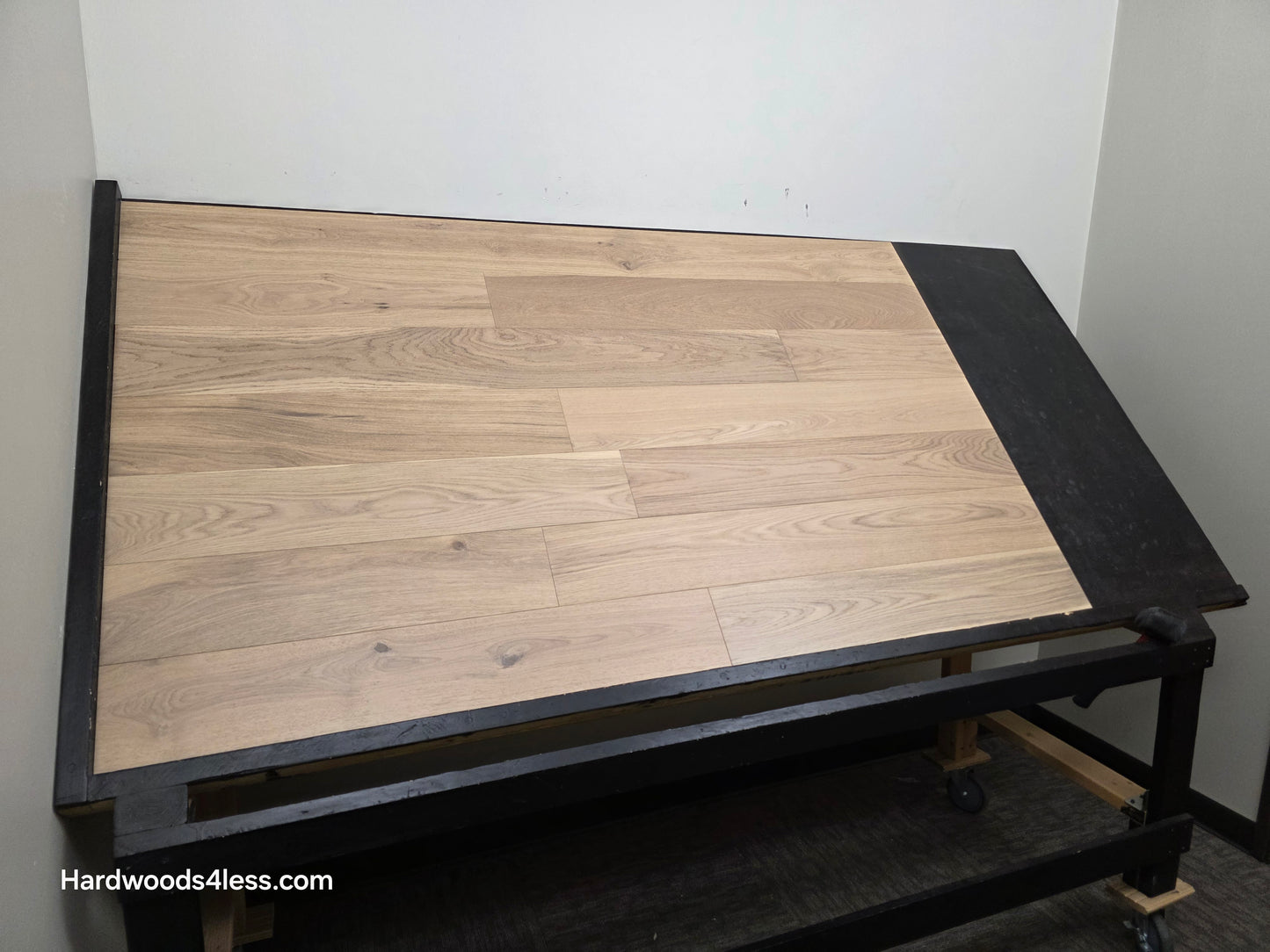 6 1/2" x 1/2" Engineered European White Oak Mojito Hardwood Flooring. Shown on a black shooting table. Shot from wide left.